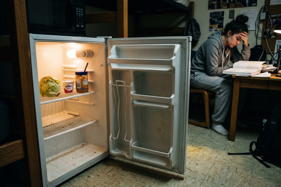 College student meal prepping affordable food in a small apartment kitchen