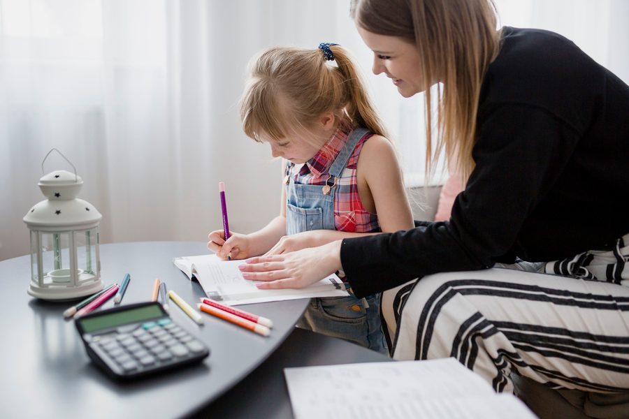 A family reviewing a childcare budget spreadsheet on a laptop