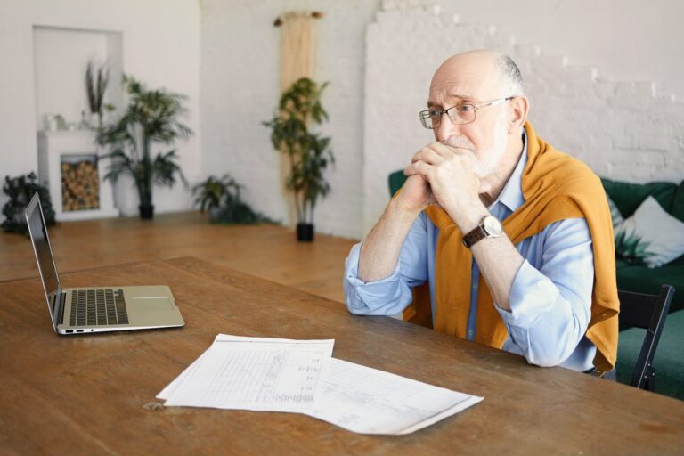 Close-up of retirement account documents with calculator and pen showing IRA rollover paperwork