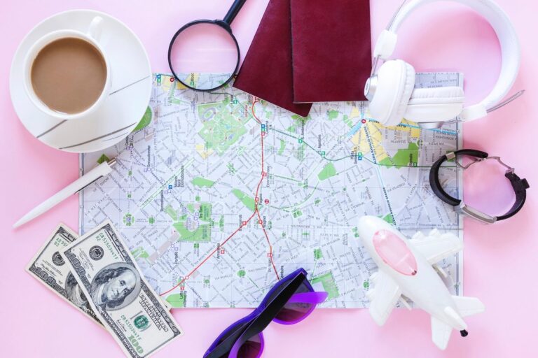 Calculator, passport, and travel itinerary on a table showing travel budget planning
