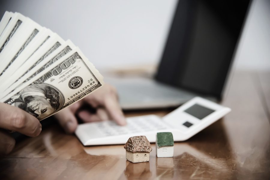 Person reviewing severance letter and calculating monthly expenses on kitchen table